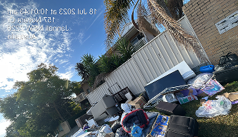 Rubbish removal worker clearing waste and debris from a flooded outdoor area in Sydney — eco-certified rubbish removal by Candid Cleaners