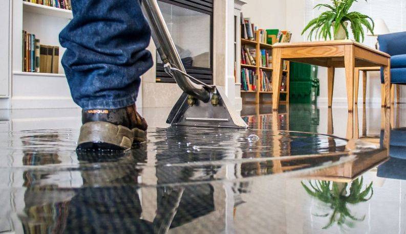 Water damage restoration technician assessing a flooded room in Sydney — IICRC S500 certified water extraction and structural drying by Candid Cleaners