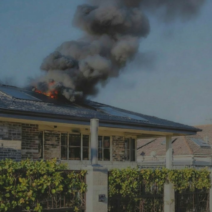 How long does fire restoration take in Sydney — active house fire with flames and black smoke rising from the roof of a Sydney brick home